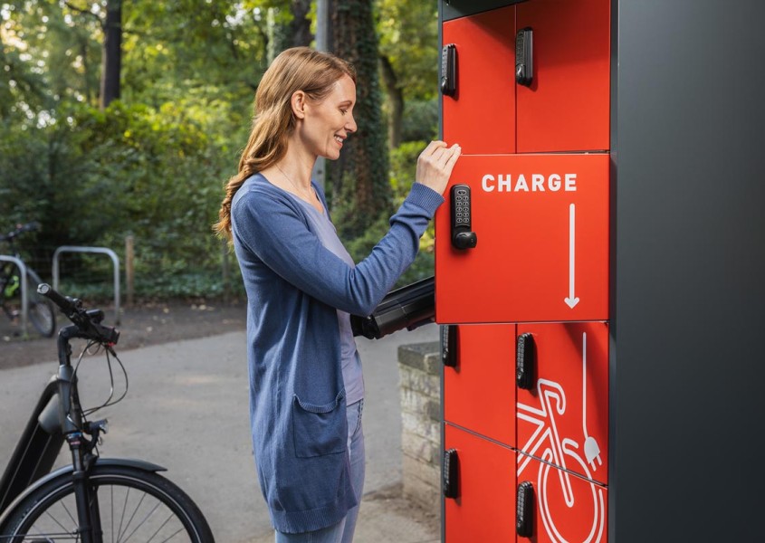 E-Bike Ladestation Frau legt Akku ins Fach | rotstahl