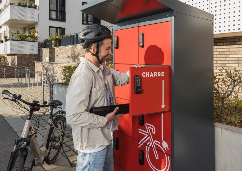E-Bike Ladestation Radfahrer legt Akku ins Fach | rotstahl