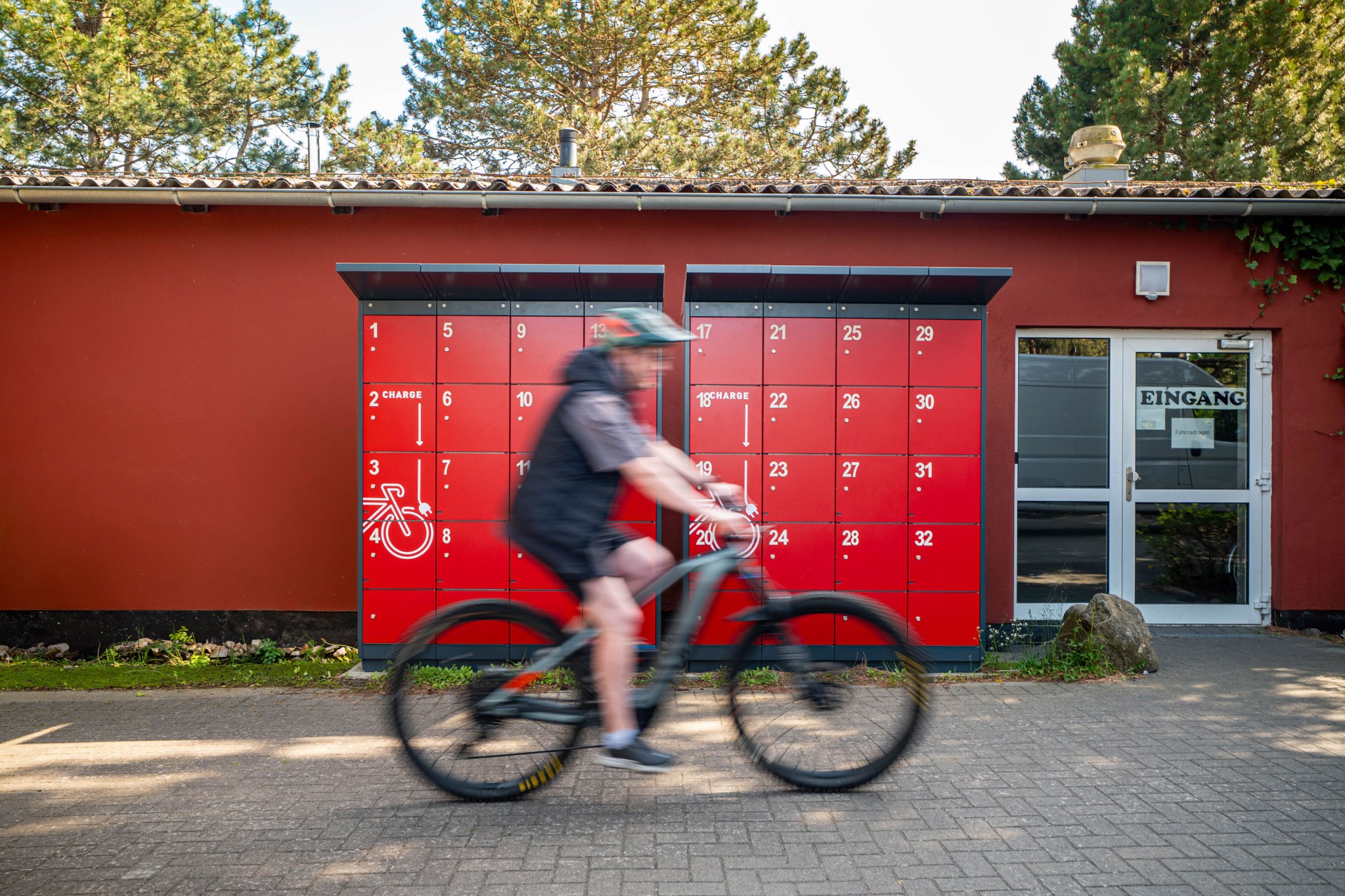 e-bike-ladestation-zingst-frontal-mit-radfahrer Zwei E-Bike Ladestation mit jeweils 16 Ladefächern in Zingst | rotstahl